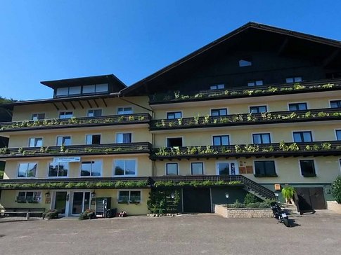 Groot rustiek chalet met balkonplanten onder heldere lucht