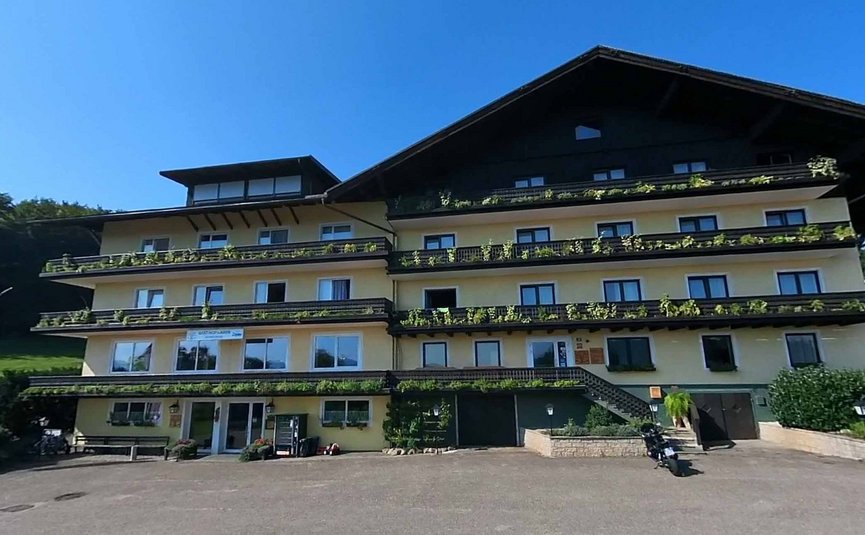 Großes uriges Chalet mit Balkonpflanzen bei klarem Himmel