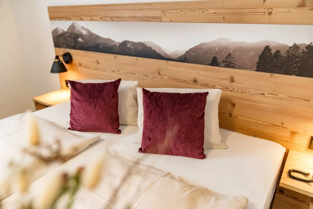 "Short but good" Bed with burgundy pillows, wooden headboard and mountain panorama