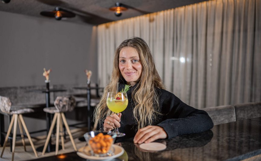 MOAR'S Hotel ***S © Harald Wisthaler Frau mit langem Haar hält ein Cocktailglas in einer Bar