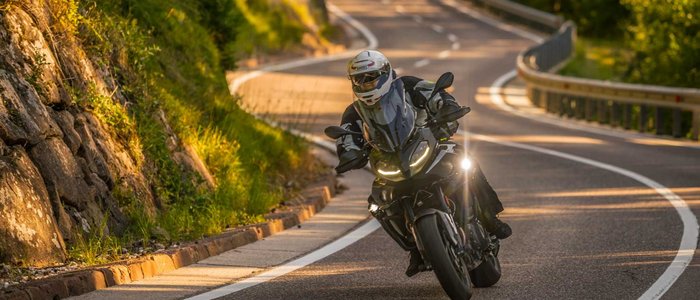 Qualitätsversprechen © Moppetfoto.de Motorradfahrer in Schutzkleidung auf kurviger Landstraße im Sonnenschein