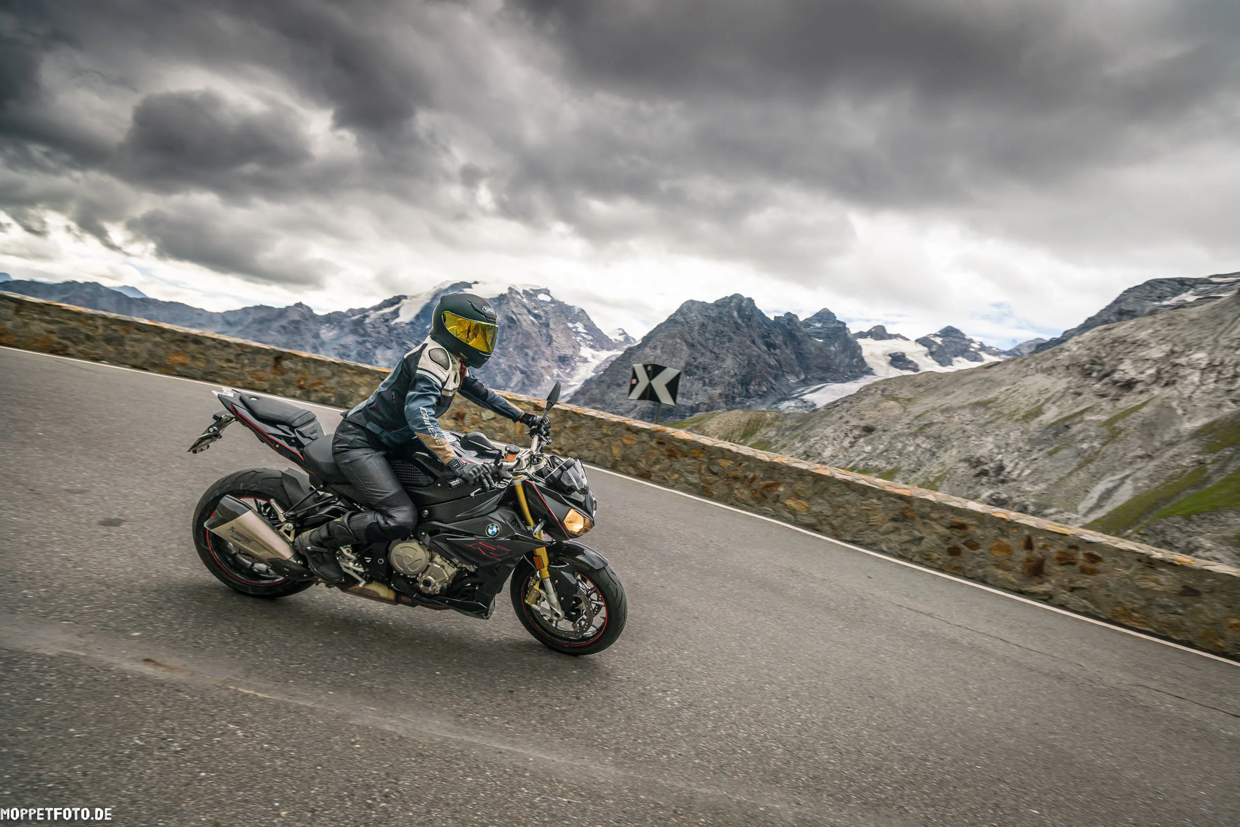 Italien © Moppetfoto.de Motorradfahrer in Schutzkleidung auf kurviger Bergstraße bei bewölktem Himmel
