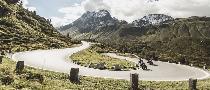Motorradurlaub in Tirol © Christoph Schöch Motorradfahrer auf kurviger Bergstraße mit schneebedeckten Gipfeln