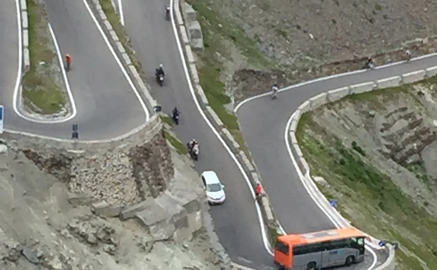 Mountain switchback road with bus and several motorcycles