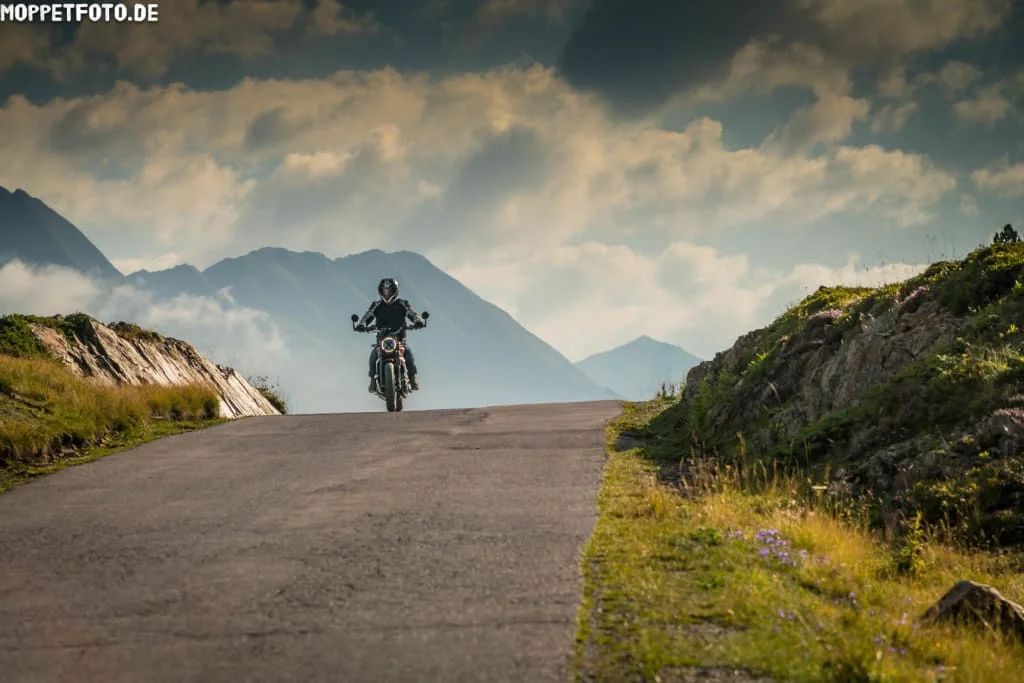 Moar's Bike & Relax Week Motorrijder op een bergweg met bergen en wolken