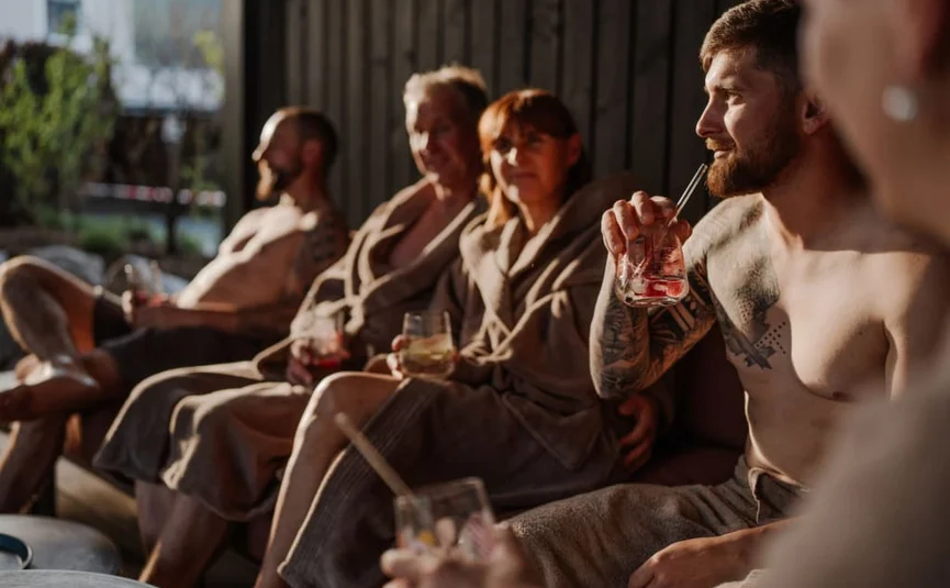 Sweaty Weekends Mensen in badjassen ontspannen met drankjes in een sauna