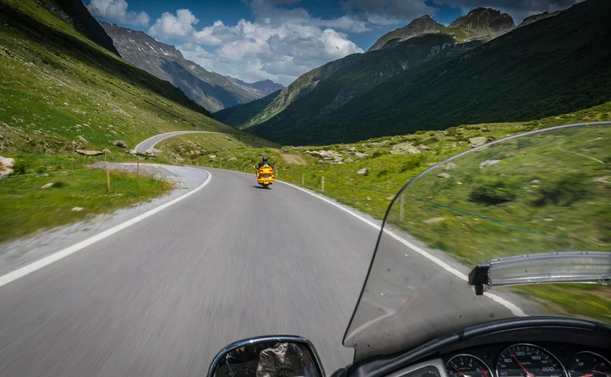 Hotel Jägerhof **** © Moppetfoto.de Blick vom Motorrad auf ein gelbes Motorrad vor einer kurvigen Straße im Bergtal