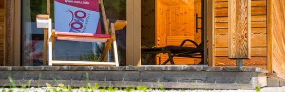 2 Center Tour Grossglockner Holzhaus mit Liegestuhl und Blick auf den Holzinnenraum