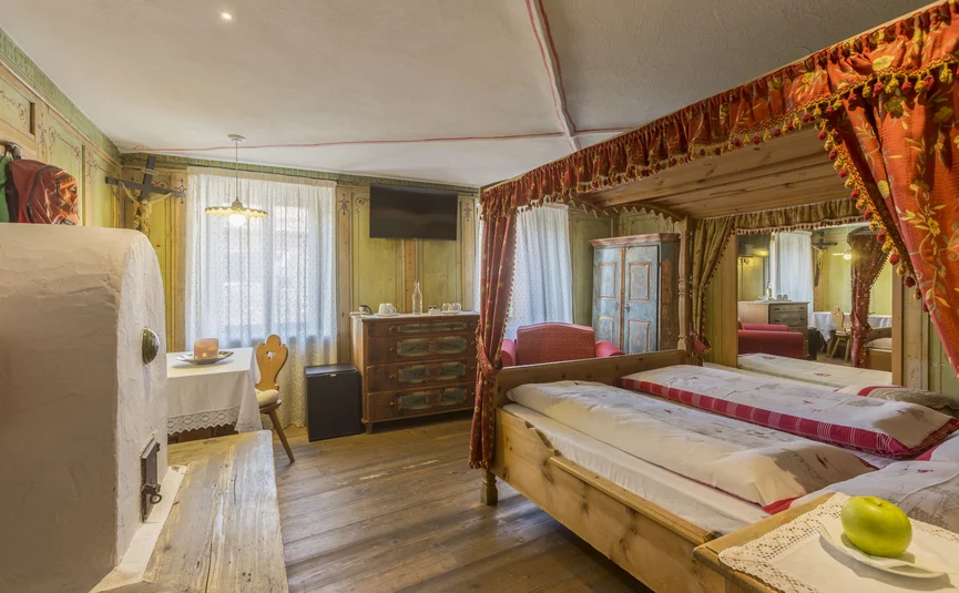 Hotel La Stüa **** © Hotel La Stüa Gemütliches rustikales Schlafzimmer mit Himmelbett und Holzmöbeln