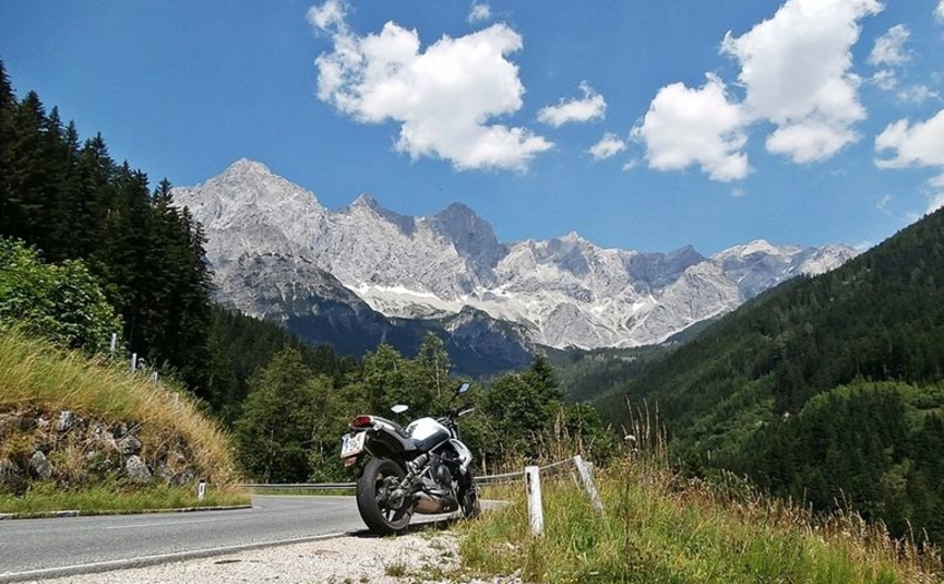 Am Fuße des Dachsteins Tour 1 Motorrad geparkt an Bergstraße mit Alpen und blauem Himmel
