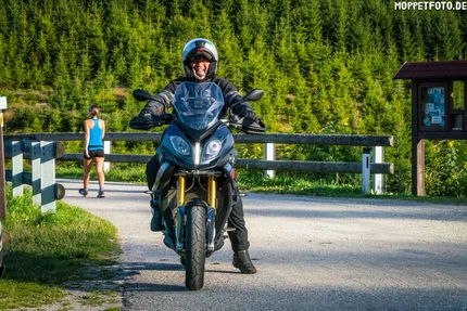 Man wearing helmet sitting on motorcycle on country road