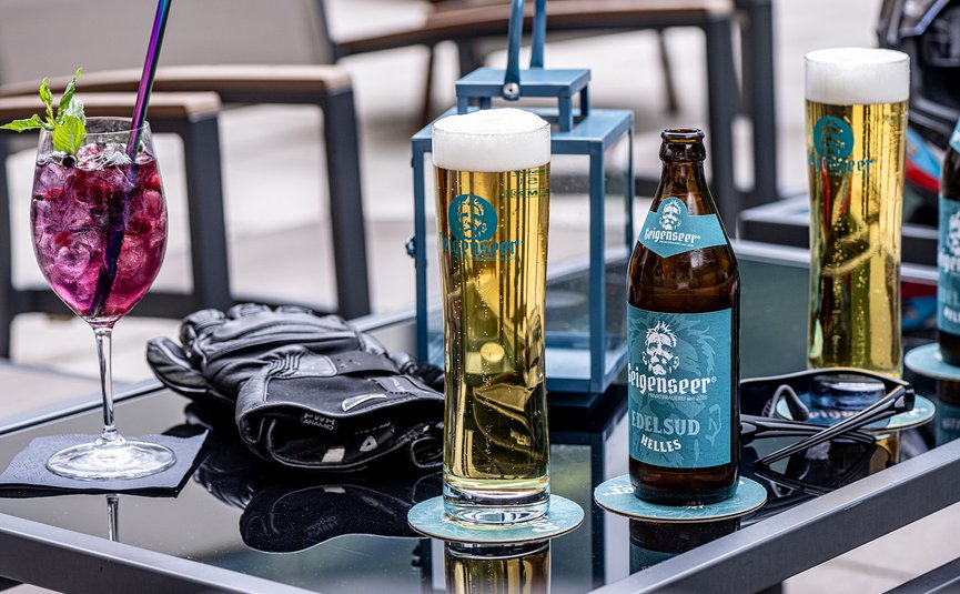 Glazen bier en cocktail op tafel met handschoenen en zonnebril