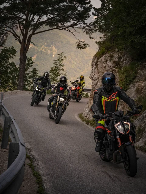Four motorcyclists riding on a winding mountain road
