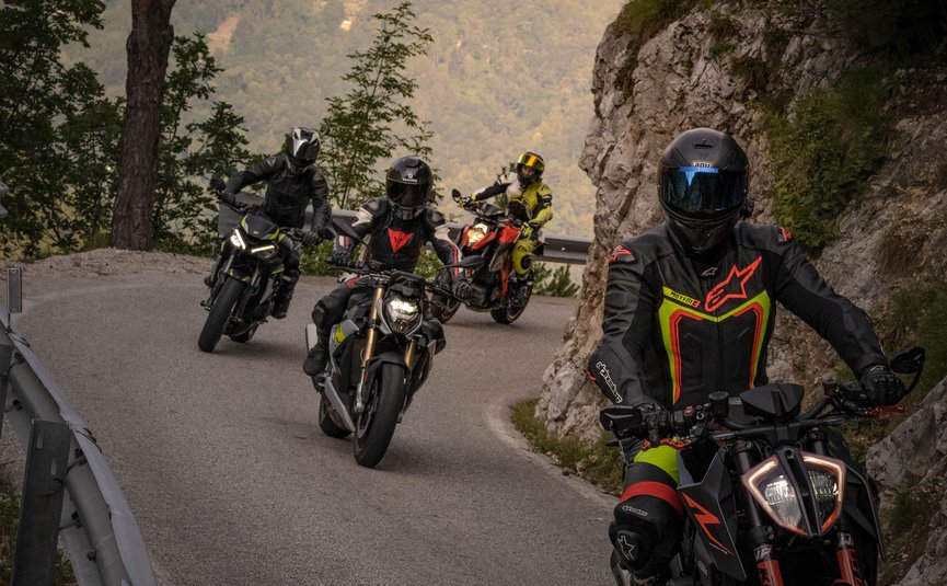 Vier Motorradfahrer fahren auf kurvenreicher Bergstraße