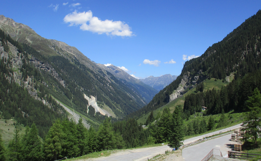 Bergtal mit grünen Bäumen und blauem Himmel