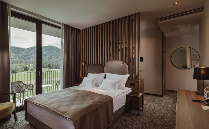 Cozy hotel room with double bed and mountain view from balcony