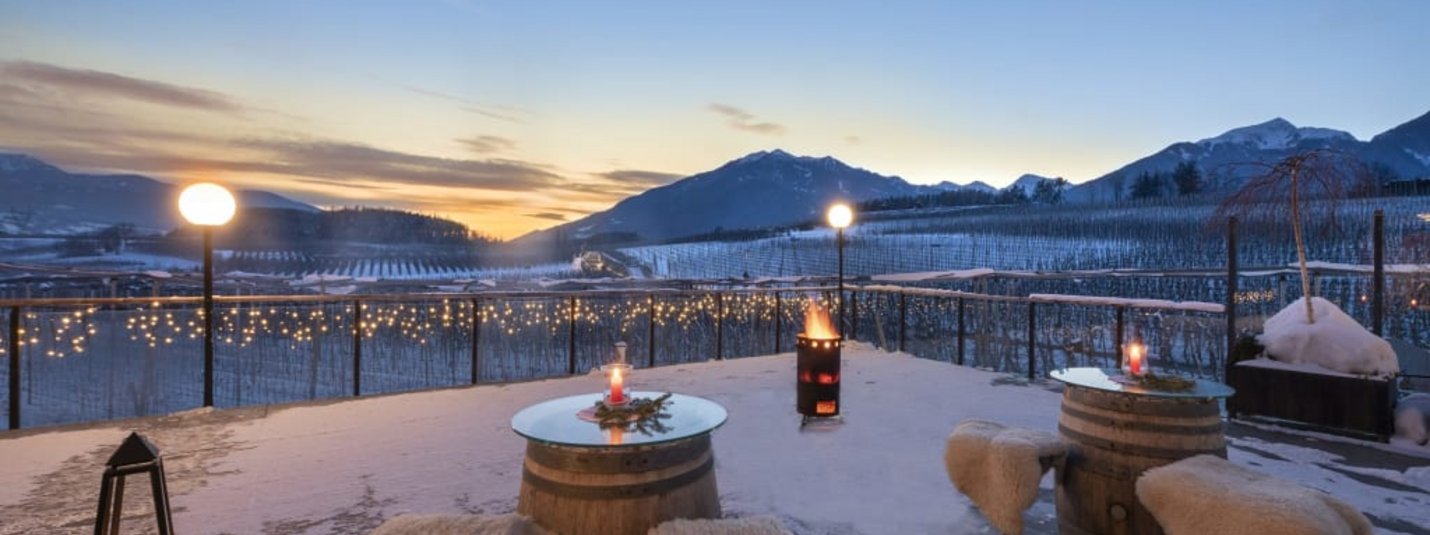 Winterterrasse mit Sitzgelegenheiten und Bergblick bei Sonnenuntergang