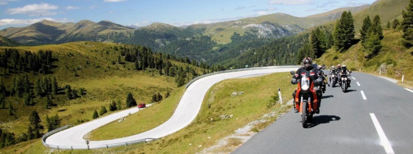 Biker-Erlebniswoche im Salzkammergut – Kurven, Panorama & Genuss Motorradfahrer fahren eine kurvige Bergstraße bei sonnigem Wetter