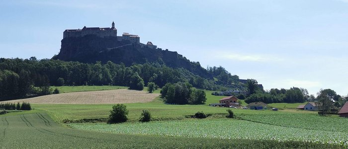 Grenzgebiet Oststeiermark-Südburgenland © Leberzipf Didi Burg auf einem Hügel mit grünen Feldern und Häusern im Vordergrund