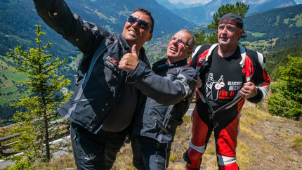 MoHo Schönauer Hof- Tour 3 Tiroler Nebenstraßen Drei Motorradfahrer machen Selfie mit Berglandschaft im Hintergrund