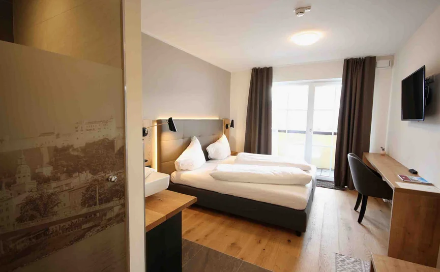 Modern hotel room with double bed and desk by the window