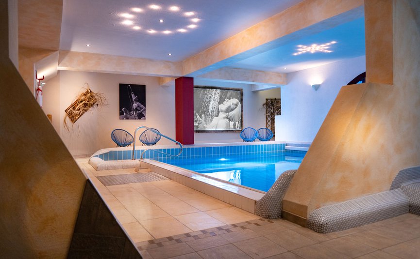 Innenpoolbereich mit stilvoller Beleuchtung und Fotokunst an den Wänden