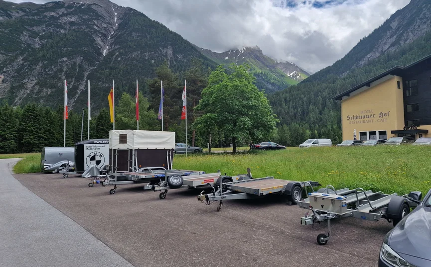 Aanhangwagens geparkeerd bij hotel in bergdal met bewolkte lucht