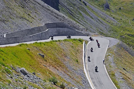 Motorcyclists and cyclist on winding mountain road
