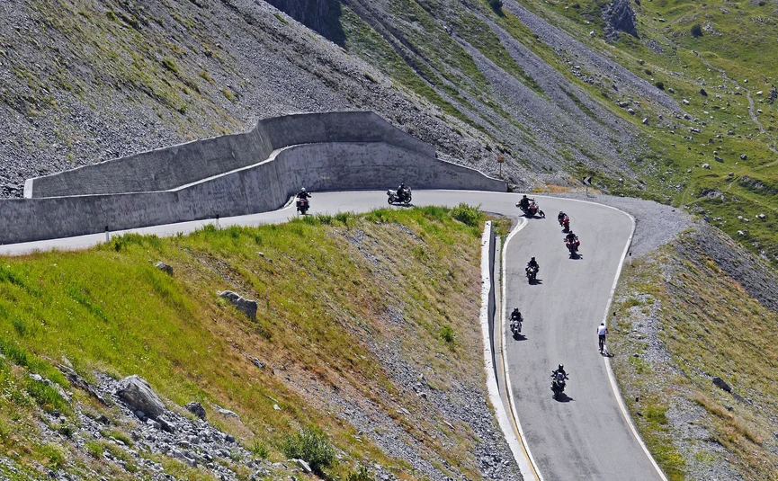 Dolomiten - Kriegerrunde Motorradfahrer und Radfahrer auf kurviger Bergstraße