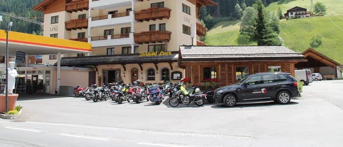 Hotel with motorcycles and car at a gas station in the mountain village