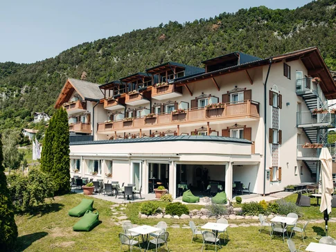 Motorrad-Hotel-Südtirol Ludwigshof © Ivan Bortondello Hotelgebäude mit Terrasse, Gartenmöbeln und Bergen im Hintergrund