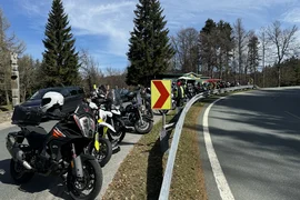 Viele Motorräder und Fahrer an einer kurvigen Straße bei klarem Himmel