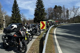 Viele Motorräder und Fahrer an einer kurvigen Straße bei klarem Himmel