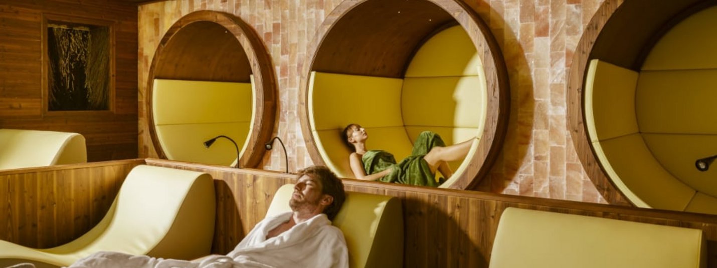 Personen entspannen in einem modernen Spa mit bequemen Liegen und Rundnischen