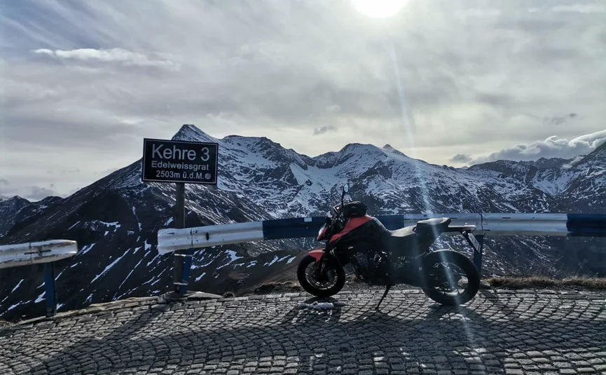Grossglockner - Felbertauern Tour Motorcycle parked at Kehre 3 at 2503m with snow-covered mountains in background