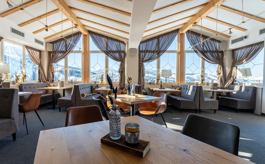 Cozy dining area with wooden ceiling and snowy mountain views