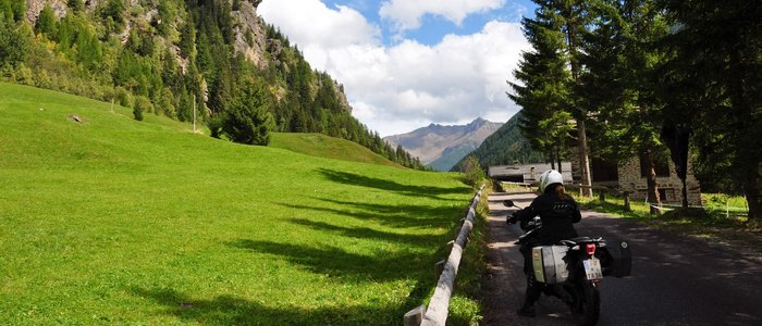 Hotel Monte Giner **** © Marisol s.n.c.di Pangrazzi Albino EC Motorradfahrer auf Bergstraße neben grünem Tal und bewaldeten Bergen