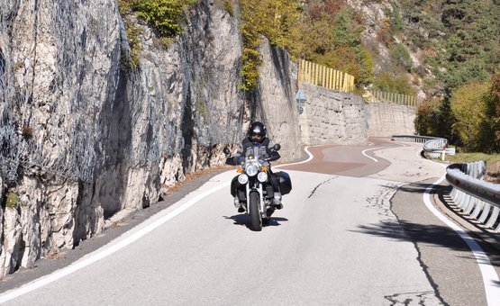 Motorradurlaub in Südtirols Süden – Kalterer See © Hotel Teutschhaus Motorradfahrer auf kurviger Bergstraße neben Felswand