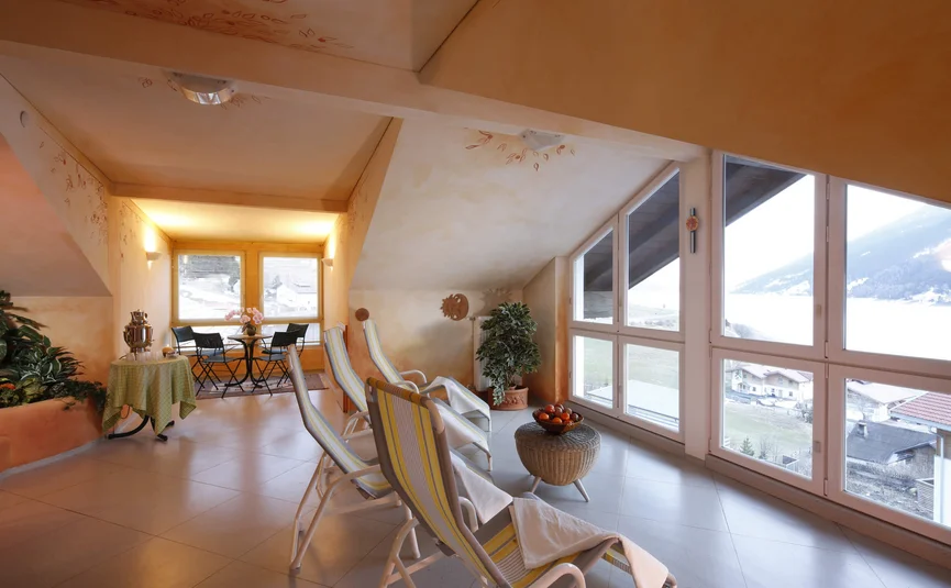 Bright room with lounge chairs and panoramic window overlooking mountains