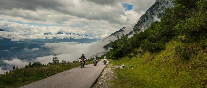 Zillertal - Alpenroute Gerlos © Moppetfoto.de Drie motoren rijden op een bergweg met wolken en groen landschap