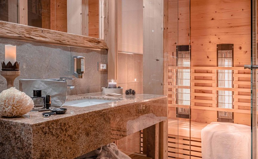 Gemütliches Badezimmer mit Holzsauna und Steinwaschbecken