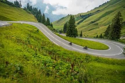 Lechtal - Hahntennjoch © Moppetfoto.de Winding mountain road with two motorcyclists and green hills