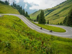 Lechtal - Hahntennjoch © Moppetfoto.de Winding mountain road with two motorcyclists and green hills