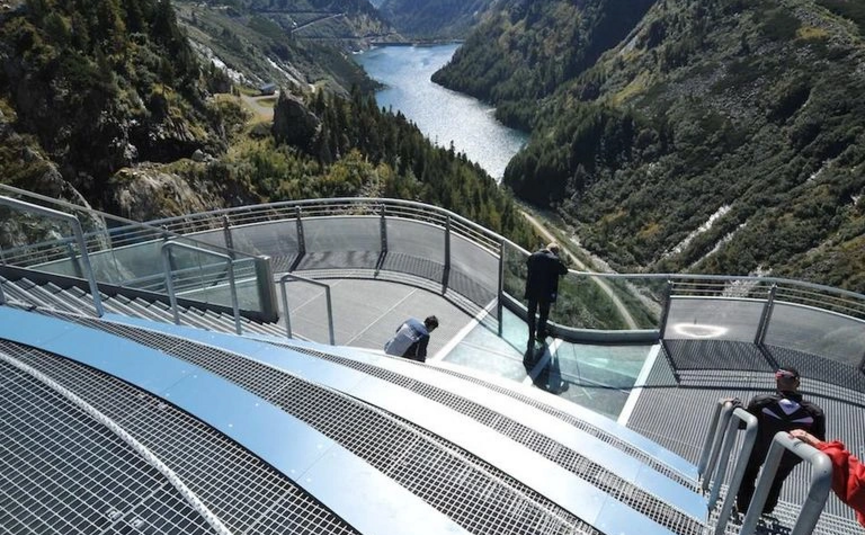 Bergblick von einer Aussichtsplattform mit Menschen und See im Tal