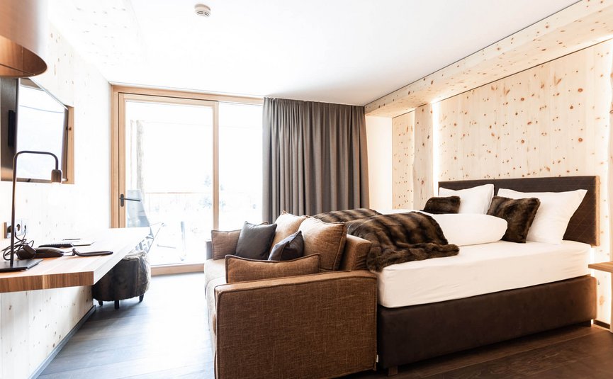 Motorrad- & Spa Hotel Traube Post am Reschensee **** © Theiner Karl-Heinz & Co KG Gemütliches Hotelzimmer mit Bett, Sofa und Terrasse