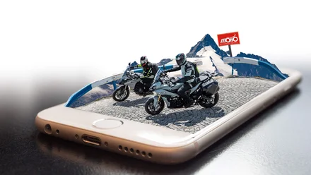 Geschichte der MoHo's Motorradfahrer auf Bergstraße erscheinen aus Smartphone-Display