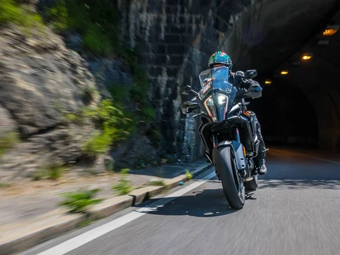 Motorradfahrer fährt in einem Tunnel an Felswand vorbei