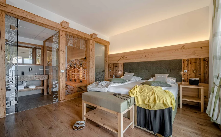 Cristallo Sport & Wellness Hotel **** © Andrea Acler Gemütliches Hotelzimmer mit Doppelbett und Sauna im Holzdesign