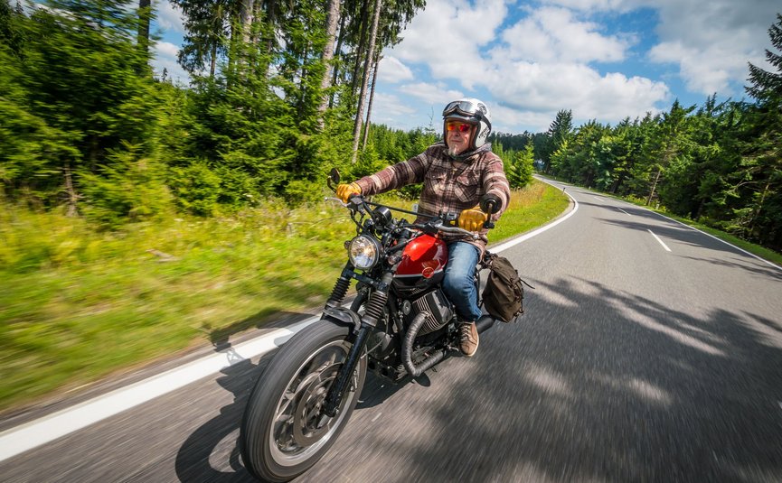 Gasthof Pension Drei Hacken *** © Moppetfoto.de Älterer Mann fährt Motorrad auf kurviger Waldstraße bei Tageslicht