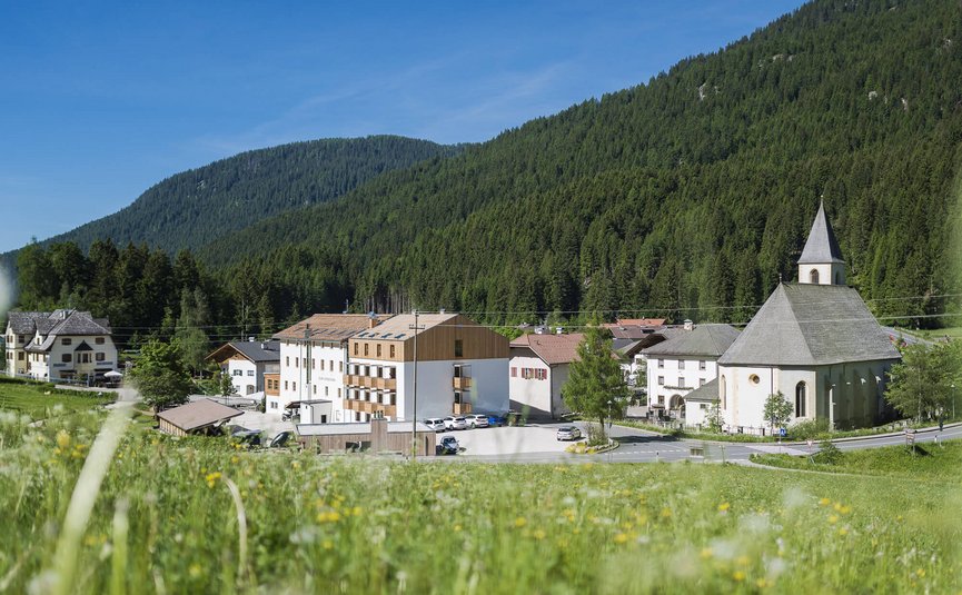 Dorp met kerk en bergen op de achtergrond onder blauwe lucht